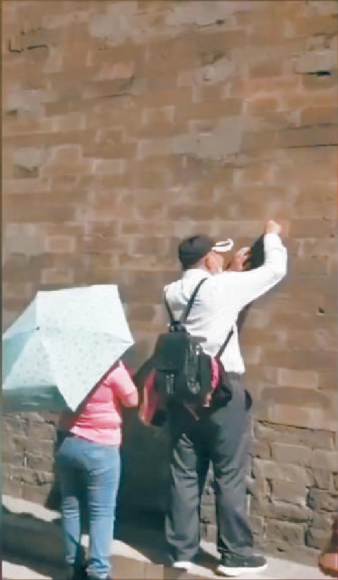 一男子在故宫城墙上刻字被行拘