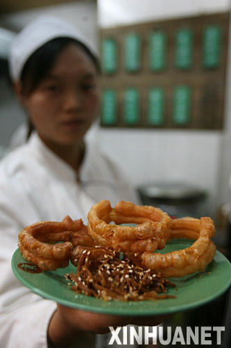 北京九门小吃德顺斋的厨师在展示焦圈和咸菜（11月3日摄）。