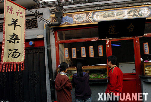 游客在北京王府井小吃一条街选购羊杂汤（10月24日摄）。